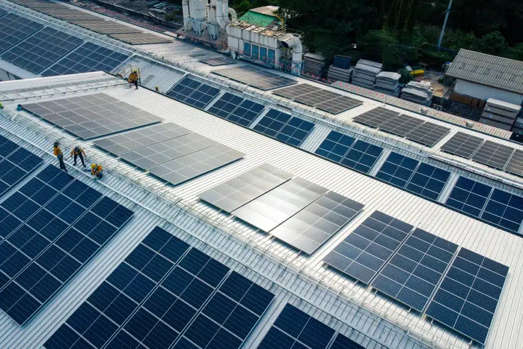 Installation de panneaux photovoltaïques sur le toit d'une usine par une équipe de techniciens.